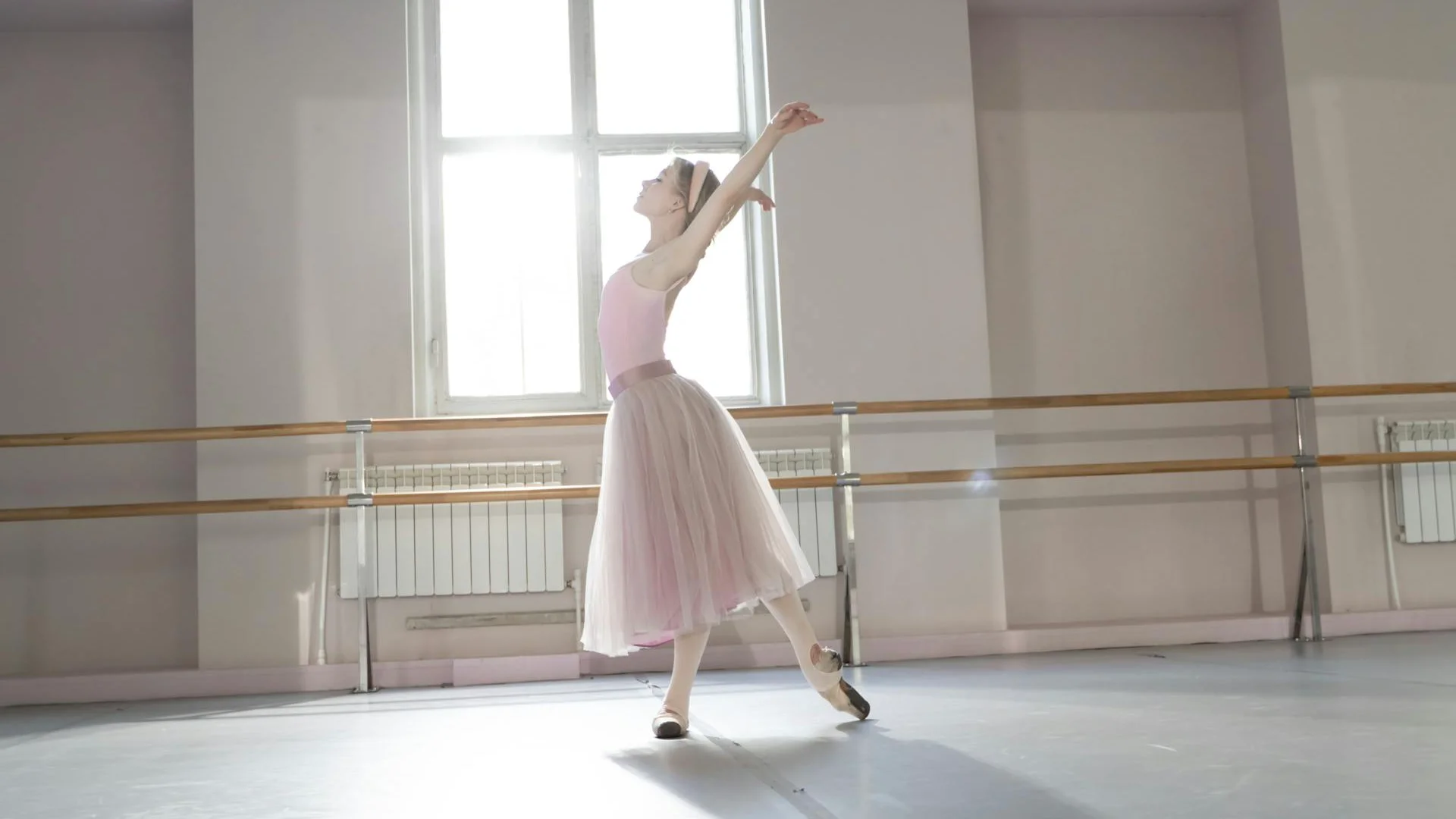 A dancer under a stage spotlight, illustrative of a New York City Ballet premiere