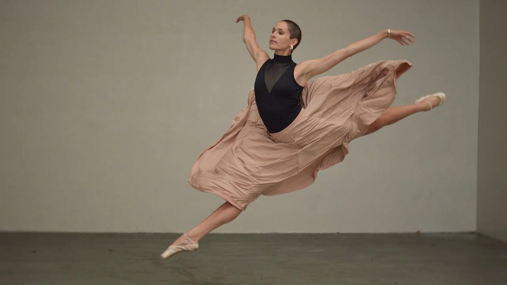 A dancer's tulle skirt caught mid-turn in an archway, illustrative of an upcoming gala premiere