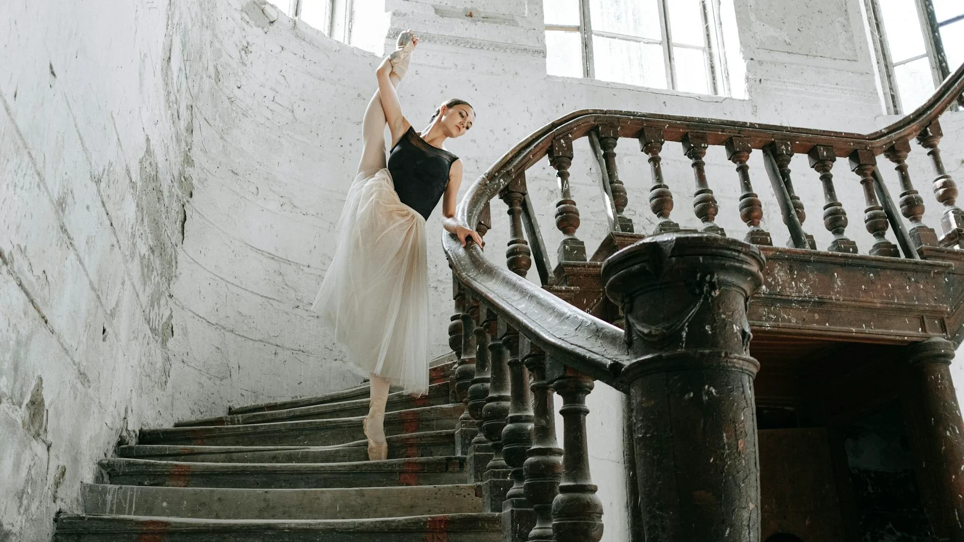 A dancer in an extreme, off-balance extension on a staircase — illustrative of Forsythe's architectural approach to ballet vocabulary