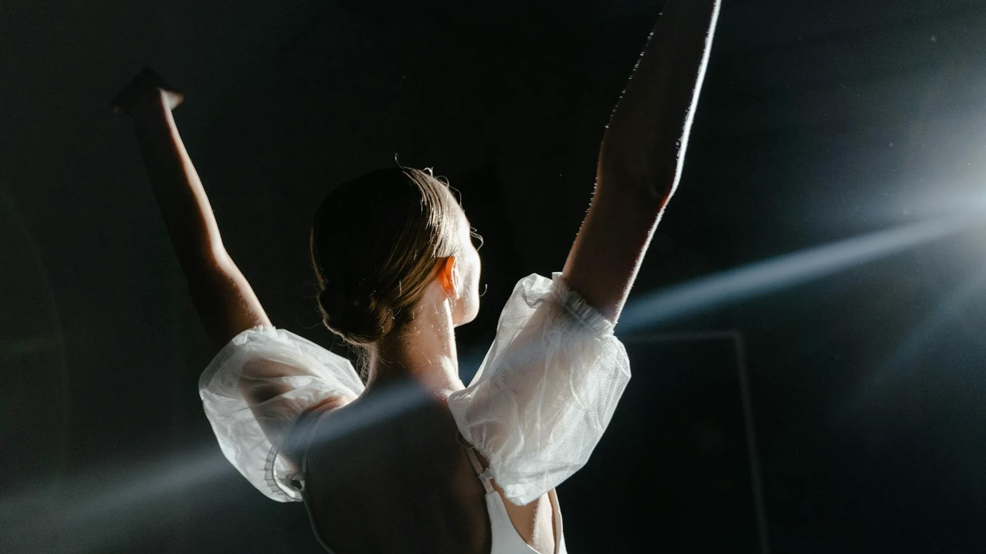 A solo dancer in a loose, grounded stance caught mid-gesture, illustrative of Kyle Abraham's house- and release-influenced choreographic style