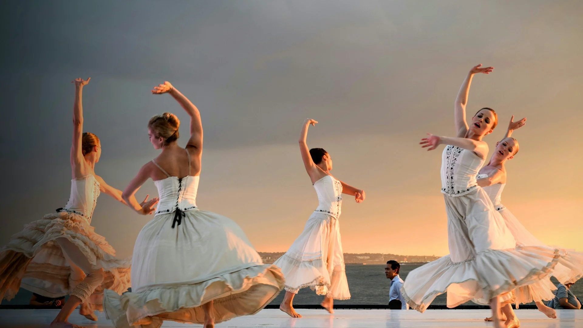 A dancer partnered closely with another representing an instrument, illustrative of The Cellist